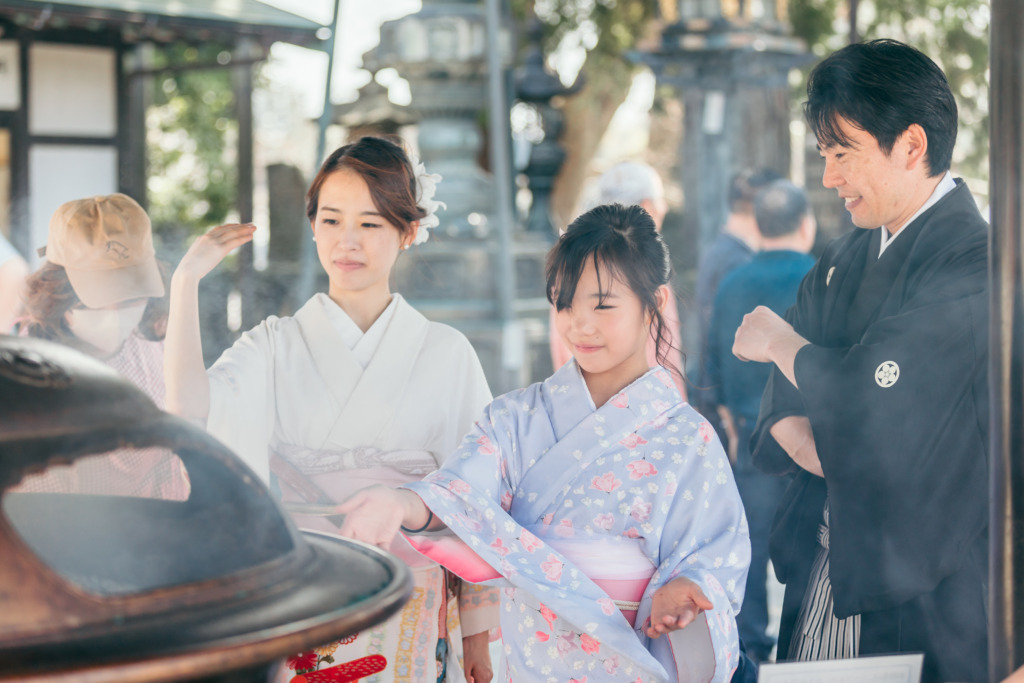 常香炉でお清めをする家族の様子