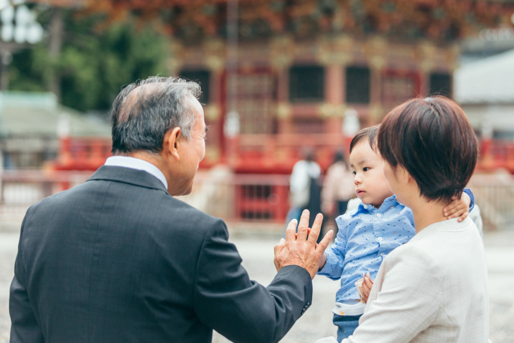 祖父とタッチをする男の子の自然な七五三写真