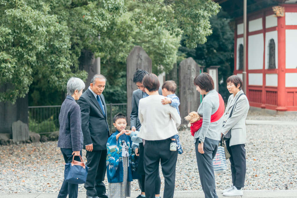 三重塔前で談笑するご家族とご親族の七五三風景