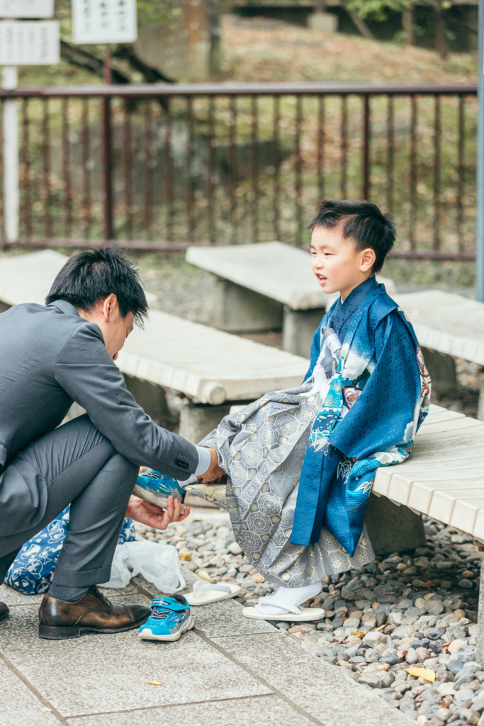 成田山公園で靴に履き替える5歳男の子の七五三写真
