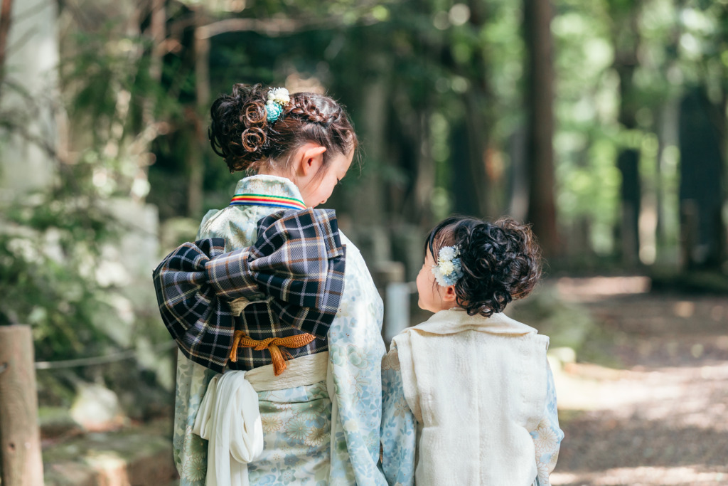 七五三の着物姿の姉妹が成田山公園で見つめ合う後ろ姿
