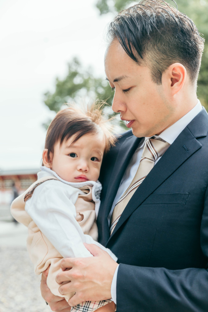 パパに抱っこされる小さなお子さまの自然な家族写真
