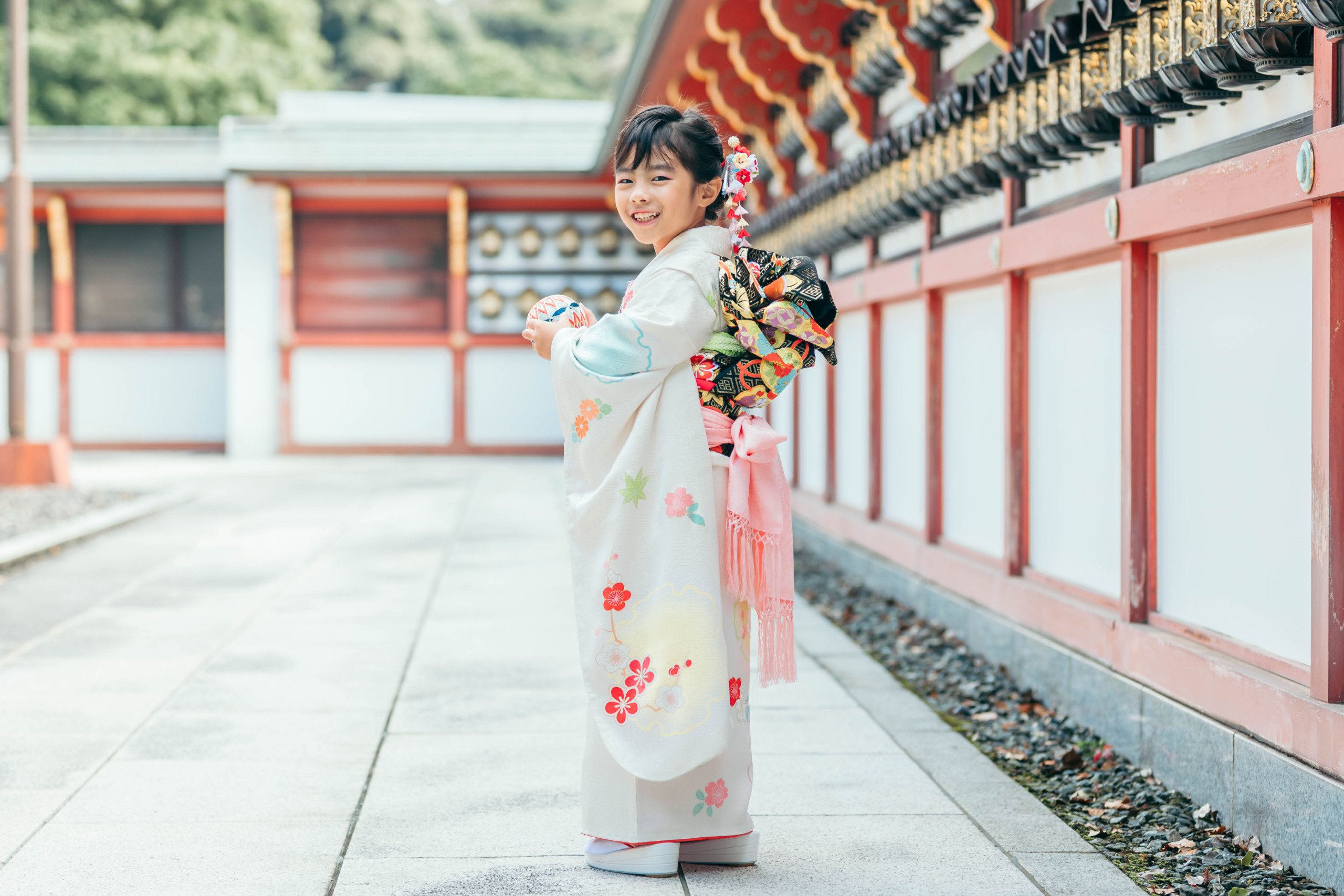 聖徳太子堂で鞠を持って微笑む7歳女の子の七五三写真
